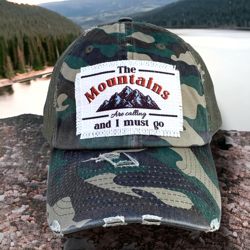 Camo mesh baseball cap with a white frayed fabric patch  (3.5x2.3 in) that says , 
