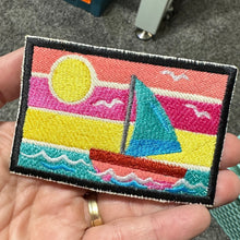 Load image into Gallery viewer, colorful embroidered rectangle patch with black border. It shows a sailboat with sunset scene.