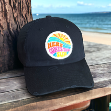 Load image into Gallery viewer, A black mesh baseball hat with cotton front and rim. 6 Panels. Distressed. It has a round 2.5 inch white fabric patch that is hand frayed. It says, &quot;Here Comes the Sun&quot; in bright colors - orange, yellow, pink, aqua, blue