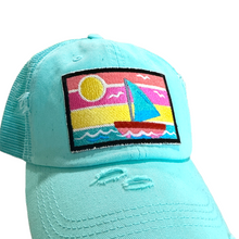 Load image into Gallery viewer, photo of aqua distressed trucker hat with embroidered sailboat patch