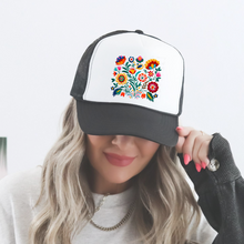 Load image into Gallery viewer, a woman wearing a faom trucker hat with a mexican floral design. Vibrant colors