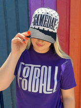 Load image into Gallery viewer, August Owl Gameday cap with black and white polka dots and black puff embroidery worn by a woman in a purple shirt