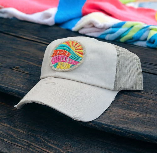 Ivory and tan mesh low profile and unstructured trucker hat with a frayed edge embroidered patch that says, here comes the sun.