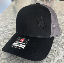 Load image into Gallery viewer, Black and charcoal mesh Richardson Low Pro 112 Trucker hat with an embroidered cowboy riding a bucking bronco. The thread is black making it tone on tone.