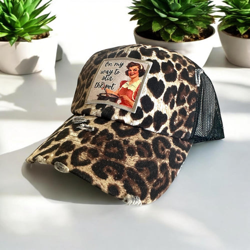 On my way to stir the pot embroidered edge patch hat. The hat is a leopard print low profile and unstructured hat with black mesh back and curved bill with slight distressing for a worn look.