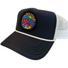 Load image into Gallery viewer, A black mid profile trucker hat with a cream rope and cream mesh. It has an embroidered here comes the sun round raggy patch. The image is embroidered onto a black frayed fabric, using bright colors of orange pink, yellow, blue and teal.