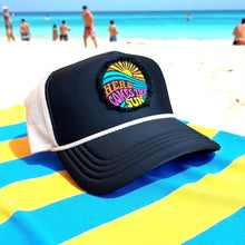 Load image into Gallery viewer, A black mid profile trucker hat with a cream rope and cream mesh. It has an embroidered here comes the sun round raggy patch. The image is embroidered onto a black frayed fabric using bright colors of orange pink, yellow, blue and teal.