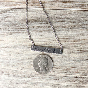 Silver hand stamped bar necklace with mountains and pine trees