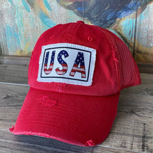 Load image into Gallery viewer, Red, low profile and unstructured, mesh trucker hat with a raggy fabric patch that says USA with a rectangle black border.
