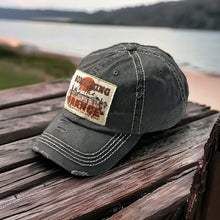Load image into Gallery viewer, Dark gray baseball hat with white stitching. It has a rectangle light tan patch that is frayed around the edges. It has a western desert scene with the words, Something in Orange tell me we&#39;re not done.